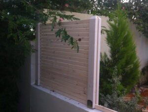 גדר עץ מעמודים גושניים ולטות מוקצעות