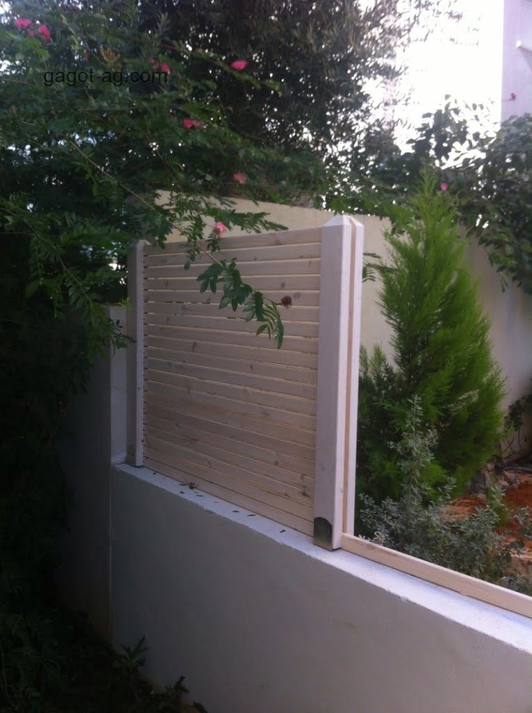 גדר עץ מעמודים גושניים ולטות מוקצעות
